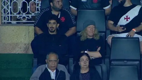 Foto: (Reprodução/Premiere) – Janick Gers, de touca, representou o Iron Maiden ao assistir ao jogo do Vasco em São Januário nesta quarta (31)