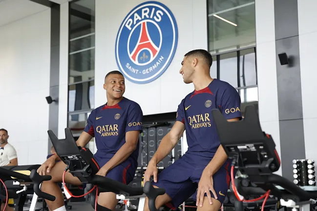 (Photo by Paris Saint-Germain Football/PSG via Getty Images) – Mbappé ao lado de Hakimi treinando na academia do clube