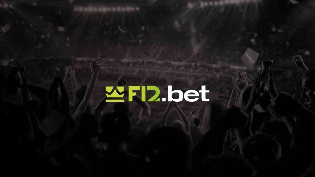 A imagem é um banner para a F12 bet. O banner está em preto e branco, e mostra pessoas em um estádio torcendo por uma partida de futebol.