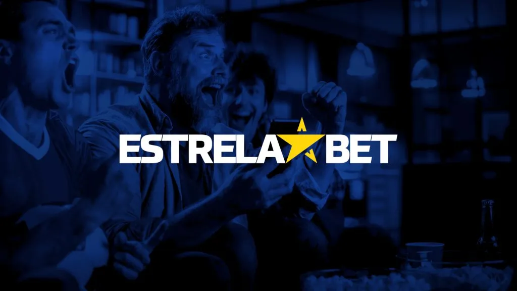 A imagem é um banner para a Estrelabet. Diz Estrelabet no centro e, ao fundo, tem uma imagem com filtro azul de três homens comemorando, um dos quais está com um celular na mão.