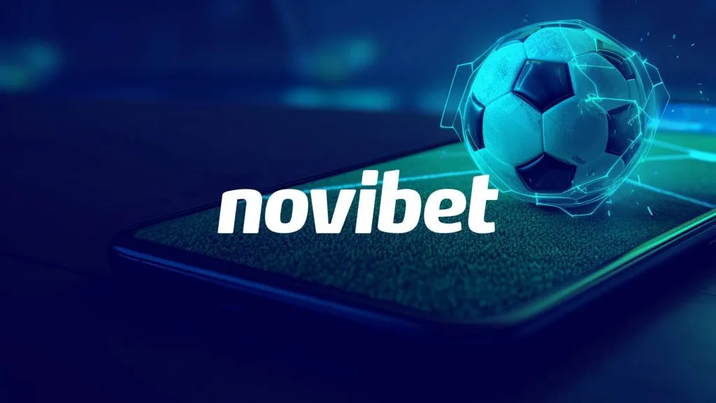 A imagem é um banner para a Novibet. Diz novibet no centro. O fundo tem um filtro azul e mostra uma bola de futebol eletrificada em cima de um celular mostrando um campo de futebol na tela.