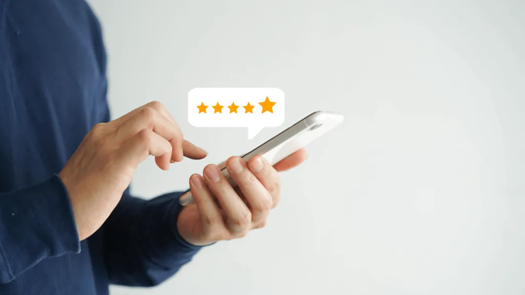 A imagem mostra uma pessoa usando um celular. Acima do celular, há um balão de texto com cinco estrelas, representando como o aplicativo e o site móvel da Betano oferecem uma boa experiência ao usuário.