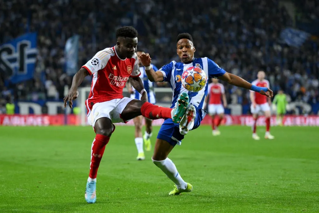 Bukayo Saka, do Arsenal, controla a bola sob pressão de Wendell, do FC Porto, durante o jogo da primeira mão dos oitavos-de-final da UEFA Champions League 2023/24 entre FC Porto e Arsenal FC, no Estádio do Dragão, a 21 de fevereiro de 2024, no Porto, Portugal. (Foto de David Ramos/Getty Images)