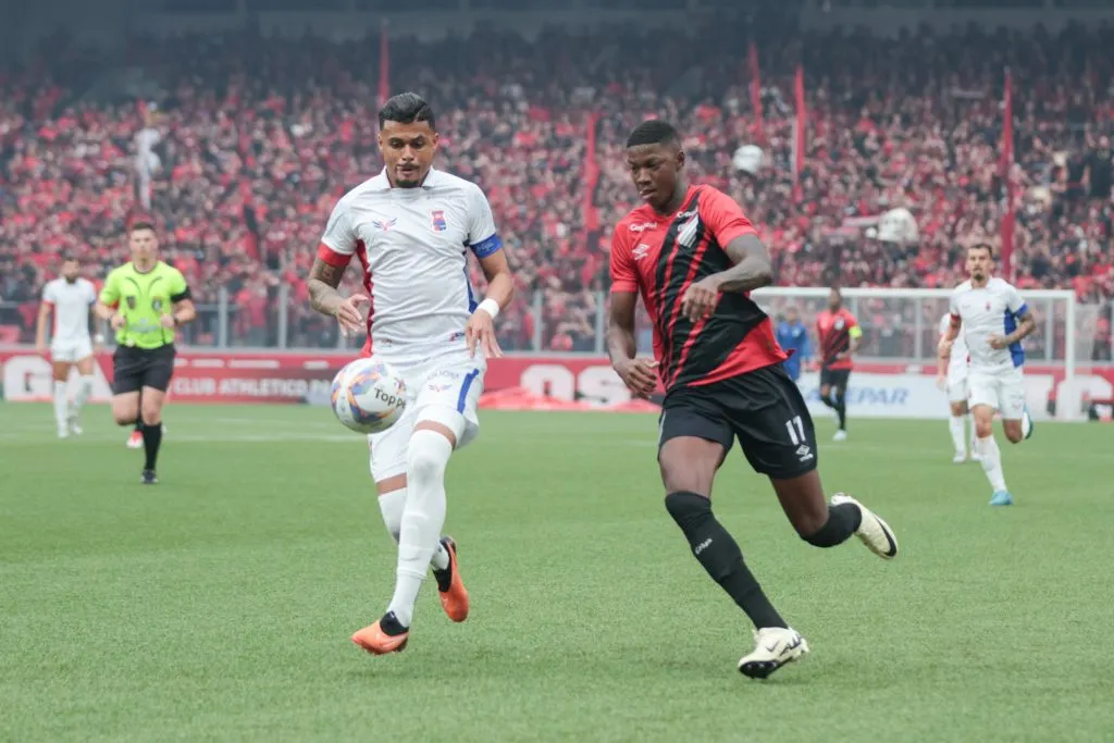 Matheus Babi jogador do Athletico-PR disputa lance com Yan Victor jogador do Paraná Clube durante partida na Arena da Baixada pelo campeonato Paranaense 2025. Foto: Robson Mafra/AGIF