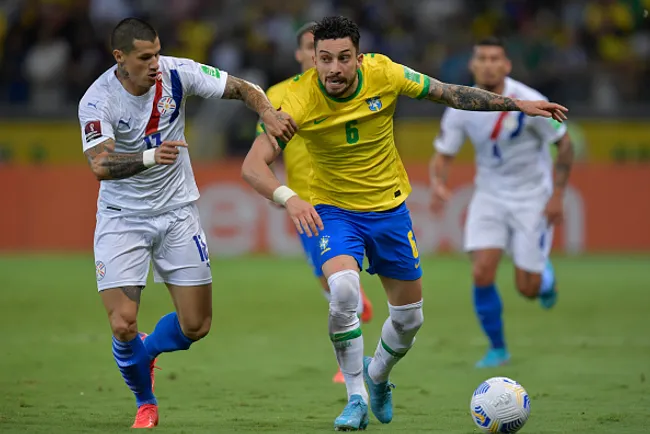 Alan Benítez disputando a bola com Alex Telles em duelo Brasil x Paraguai nas eliminatórias para Copa de 2022 – (Photo by Pedro Vilela/Getty Images)