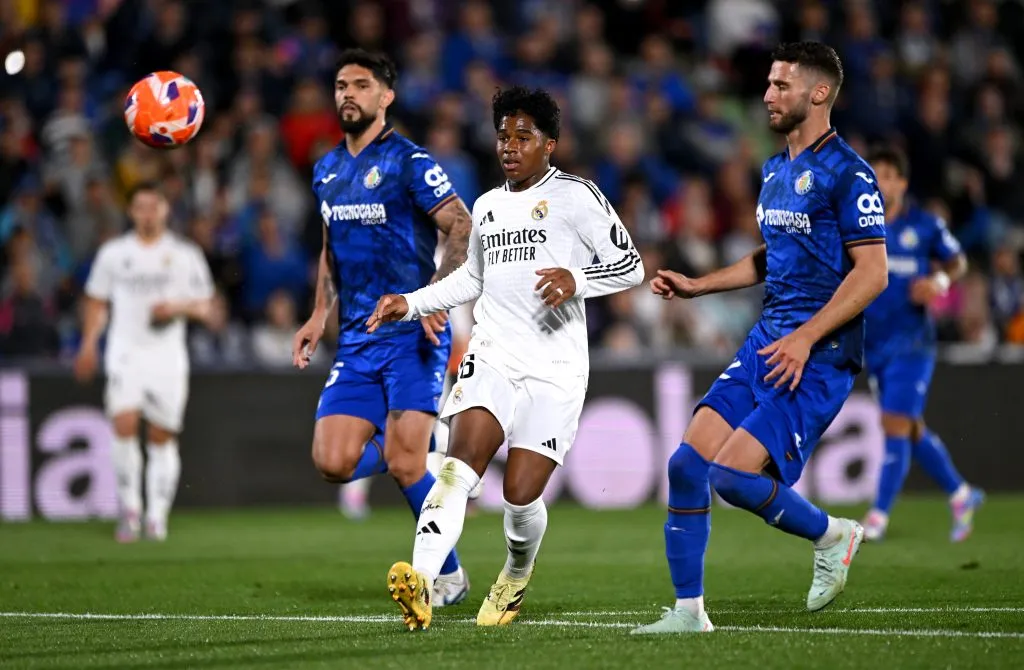 GETAFE, SPAIN – APRIL 23: Endrick of Real Madrid passes the ball under pressure from Luis Milla and Domingos Duarte of Getafe CF during the LaLiga match between Getafe CF and Real Madrid CF at Coliseum Alfonso Perez on April 23, 2025 in Getafe, Spain. (Photo by Denis Doyle/Getty Images)