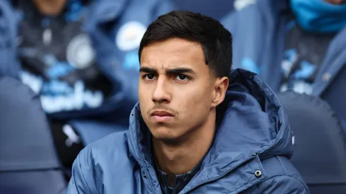 MANCHESTER, ENGLAND – MARCH 15: Vitor Reis of Manchester City looks on from the substitutes bench during the Premier League match between Manchester City FC and Brighton & Hove Albion FC at Etihad Stadium on March 15, 2025 in Manchester, England. (Photo by Matt McNulty/Getty Images)