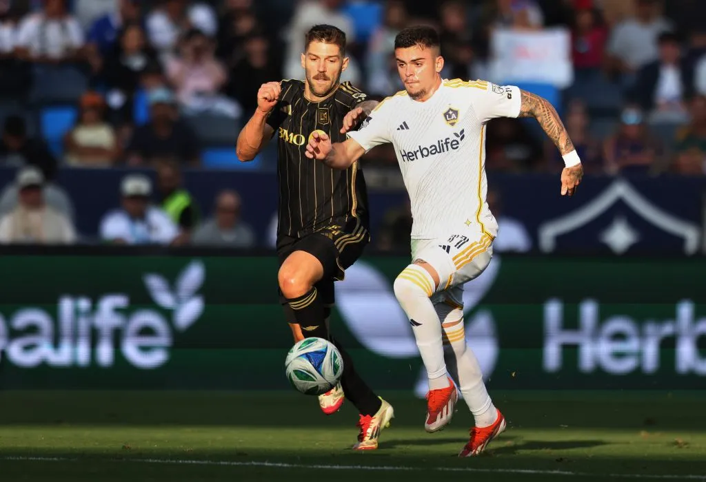 CARSON, CALIFORNIA – MAY 18: Gabriel Pec #11 of the LA Galaxy plays the ball forward as Ryan Hollingshead #24 of the Los Angeles Football Club gives pursuit during the first half of their derby match at Dignity Health Sports Park on May 18, 2025 in Carson, California. (Photo by Luiza Moraes/Getty Images)