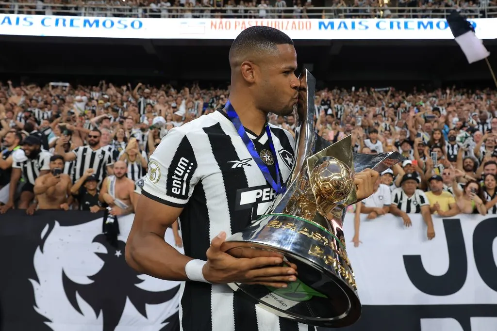 RIO DE JANEIRO, BRAZIL – DECEMBER 08: Junior Santos of Botafogo kisses the champions trophy after a match between Botafogo and Sao Paulo as part of Brasileirao 2024 at Estadio Olímpico Nilton Santos on December 08, 2024 in Rio de Janeiro, Brazil. (Photo by Buda Mendes/Getty Images)