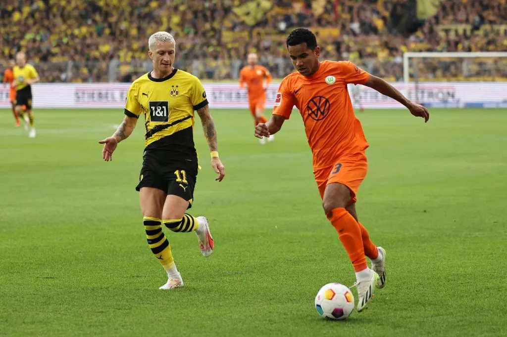 DORTMUND, GERMANY – SEPTEMBER 23: Rogerio of VfL Wolfsburg (R) controls the ball whilst under pressure from Marco Reus of Borussia Dortmund during the Bundesliga match between Borussia Dortmund and VfL Wolfsburg at Signal Iduna Park on September 23, 2023 in Dortmund, Germany. (Photo by Christof Koepsel/Getty Images)
