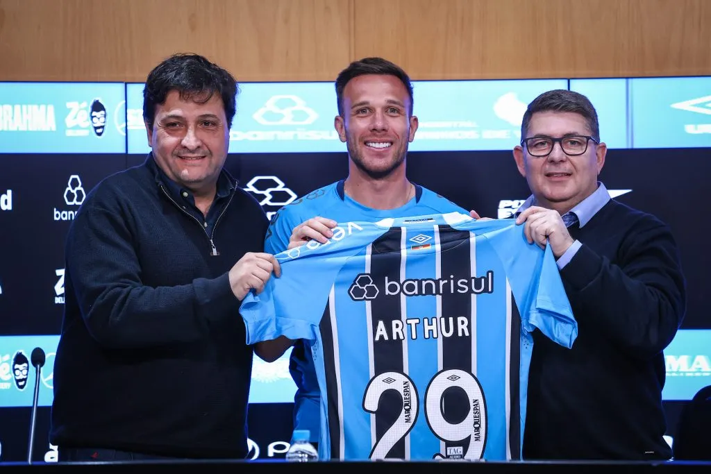 Arthur recebe a camisa do Grêmio das mãos de Alberto Guerra e Alexandre Rossato. FOTO: LUCAS UEBEL/GREMIO FBPA
