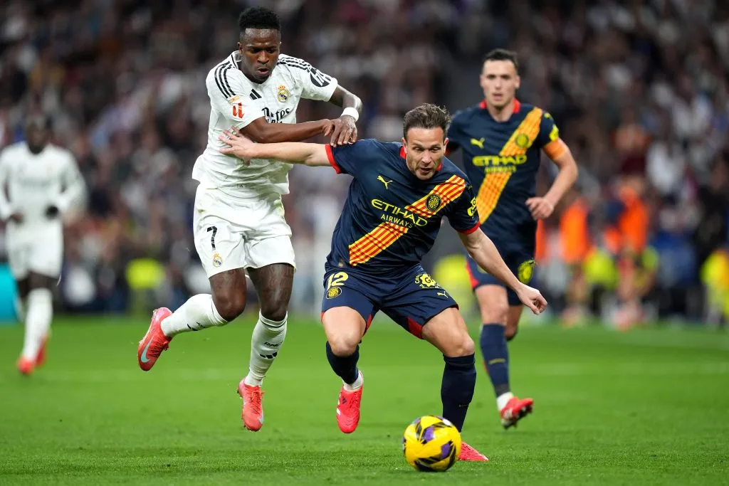 MADRID, SPAIN – FEBRUARY 23: Arthur Melo of Girona FC looks to control the ball whilst under pressure from Vinicius Junior of Real Madrid during the LaLiga match between Real Madrid CF and Girona FC at Estadio Santiago Bernabeu on February 23, 2025 in Madrid, Spain. (Photo by Angel Martinez/Getty Images)