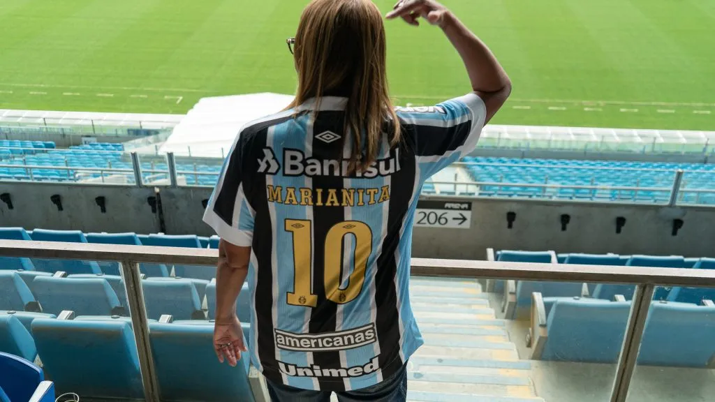 Marianita recebe camisa icônica do clube durante visita na Arena – Foto: Divulgação Grêmio