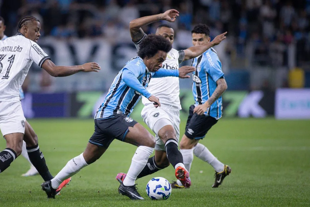 Willian jogador do Gremio disputa lance com Marlon Freitas jogador do Botafogo durante partida no estadio Arena do Gremio pelo campeonato Brasileiro A 2025. Foto: Maxi Franzoi/AGIF