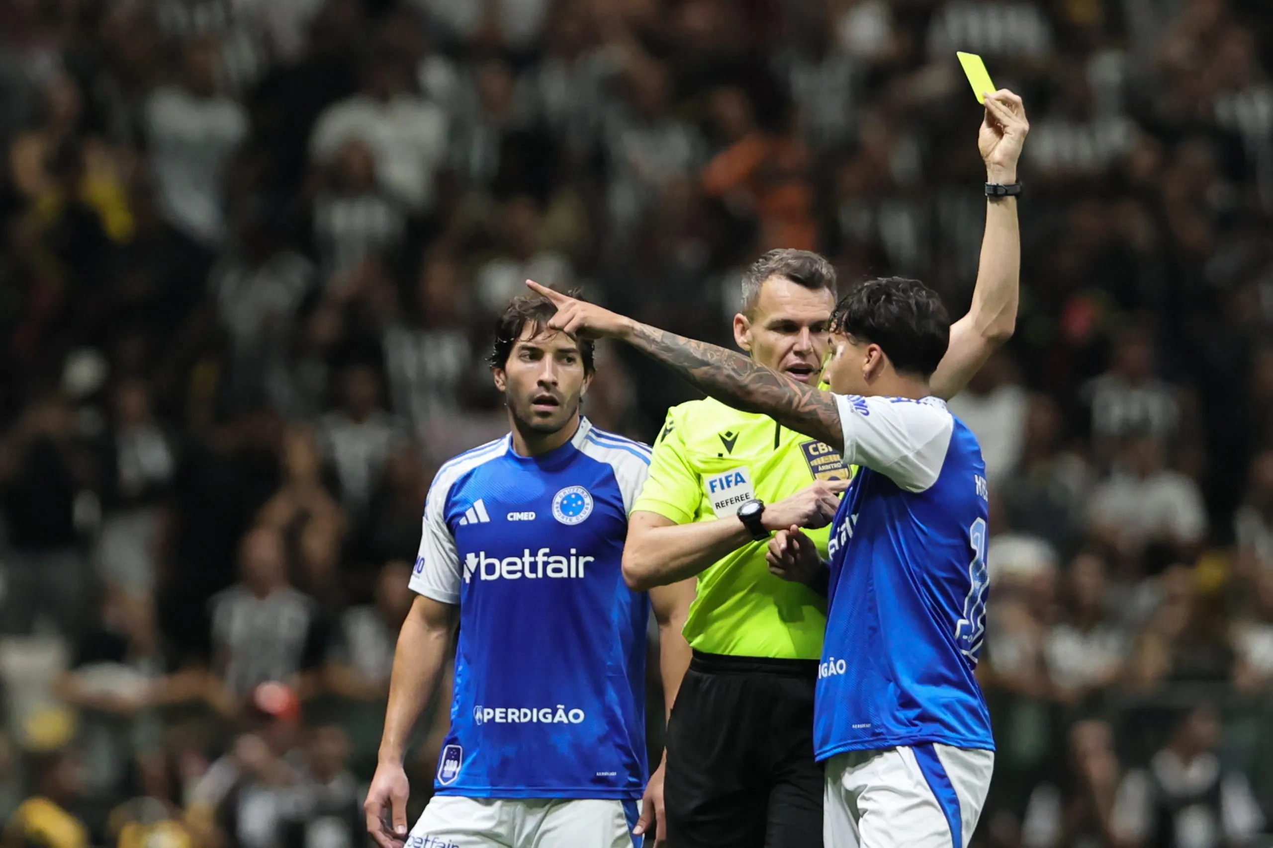 Kaio Jorge jogador do Cruzeiro recebe cartao amarelo do arbitro Paulo Cesar Zanovelli durante partida contra o Atlético-MG no estadio Arena MRV pelo campeonato Brasileiro A 2025. Foto: Gilson Lobo/AGIF