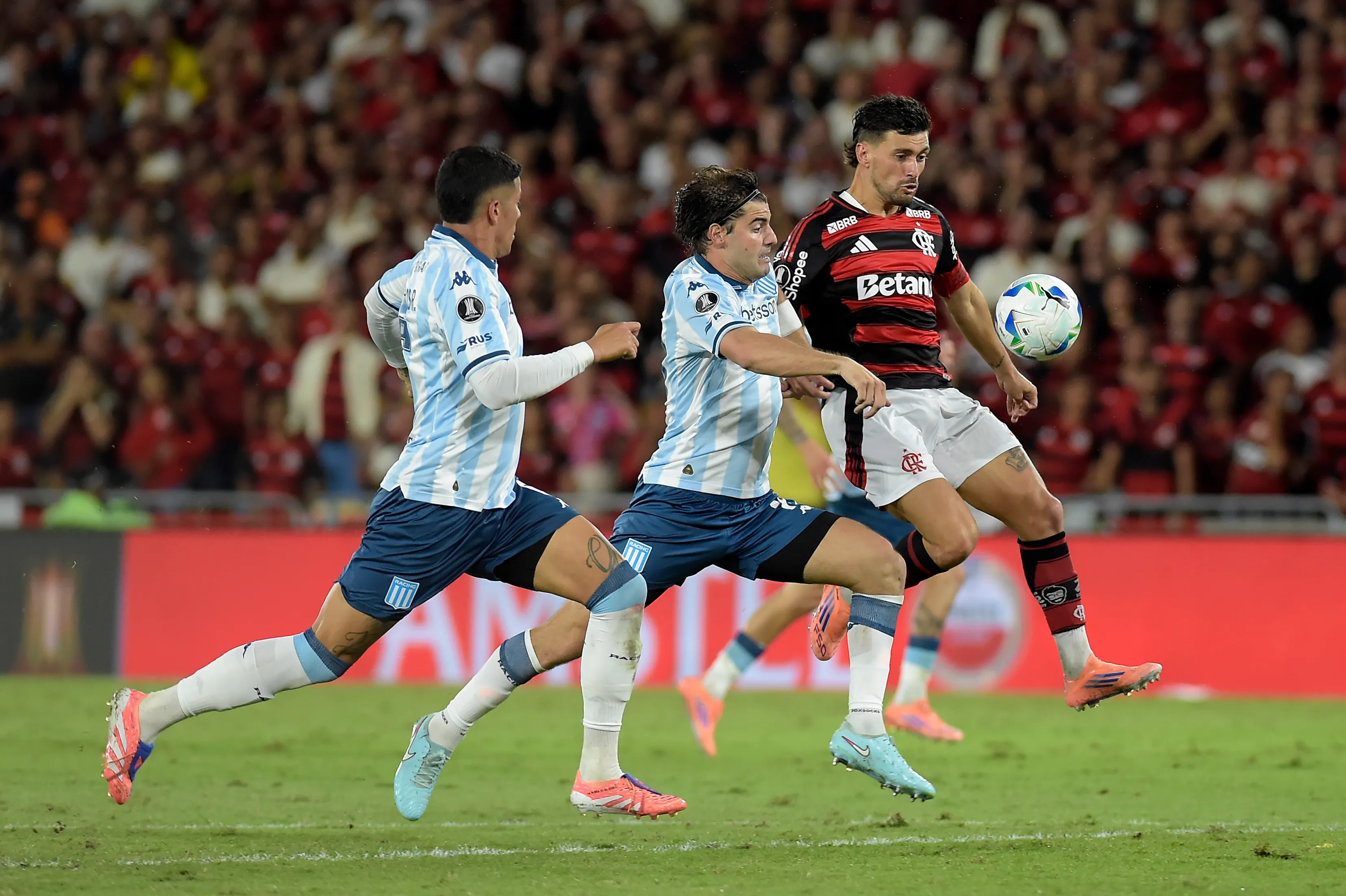 RIO DE JANEIRO, BRAZIL – OCTOBER 22: Giorgian de Arrascaeta of Flamengo is challenged by Santiago Sosa of Racing Club during the Copa CONMEBOL Libertadores 2025 first-leg semi-final match between Flamengo and Racing Club at Maracana Stadium on October 22, 2025 in Rio de Janeiro, Brazil. (Photo by Dhavid Normando/Getty Images)