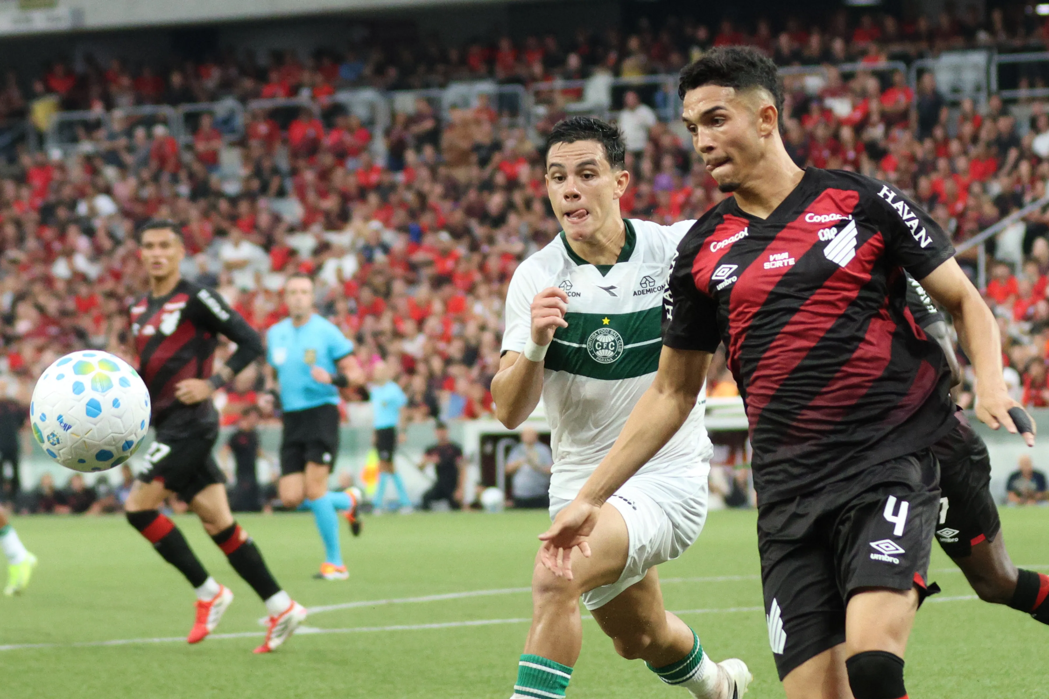 PR – CURITIBA – 22/03/2026 – BRASILEIRO A 2026, ATHLETICO-PR X CORITIBA – Arthur Dias jogador do Athletico-PR disputa lance com JP Chermont jogador do Coritiba durante partida no estadio Arena da Baixada pelo campeonato Brasileiro A 2026. Foto: Robson Mafra/AGIF