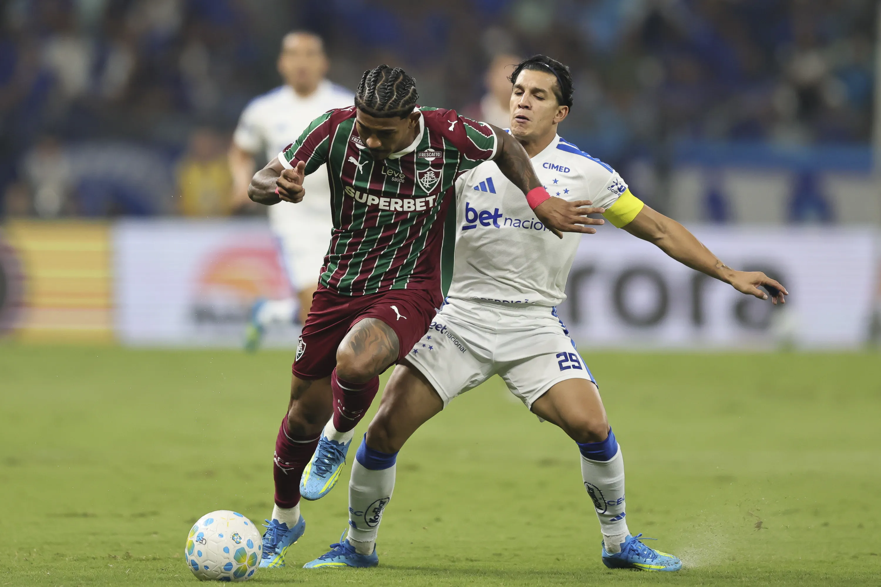 Lucas Romero jogador do Cruzeiro disputa lance com John Kennedy jogador do Fluminense durante partida no estadio Mineirao pelo campeonato Brasileiro A 2026. Foto: Gilson Lobo/AGIF