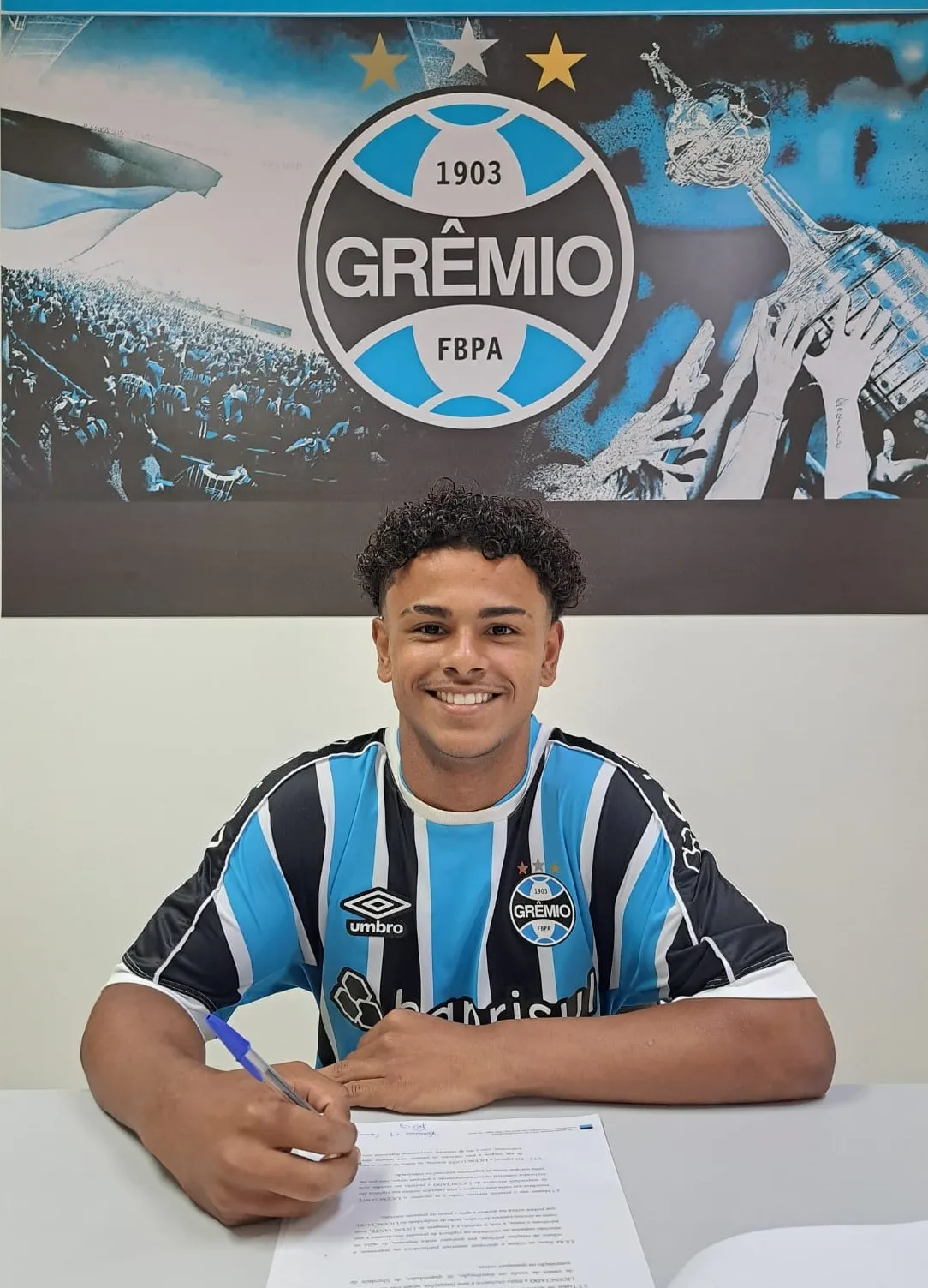 Vini Ferraz, atacante do Grêmio, assinnando primeiro contrato profissional (Imagem: Divulgação/Grêmio)